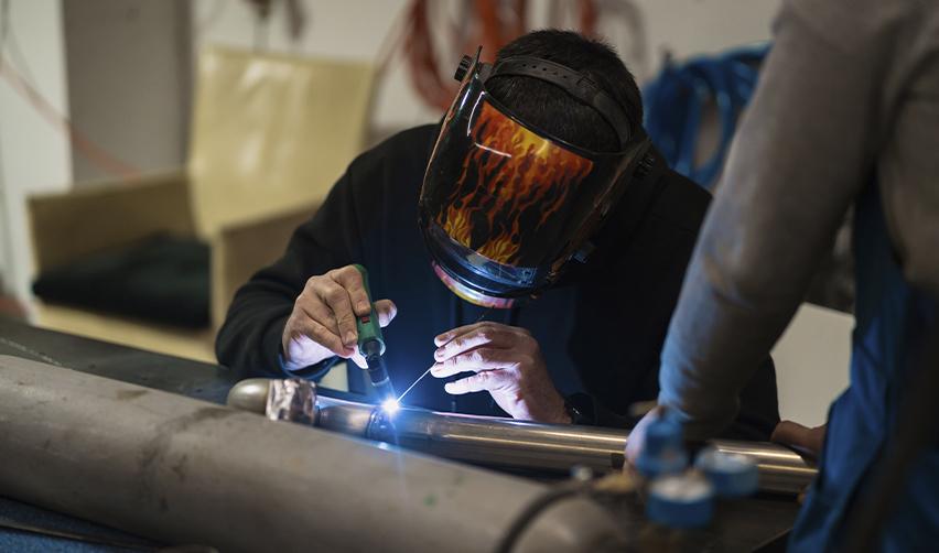 Skilled worker welding in a U.S. workshop, representing Indian workers seeking Green Card opportunities in America.
