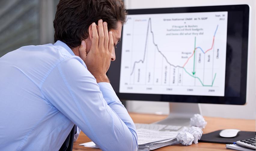 Concerned H1B worker analyzing economic graphs, reflecting the impact of tariff wars and tech layoffs on global markets.