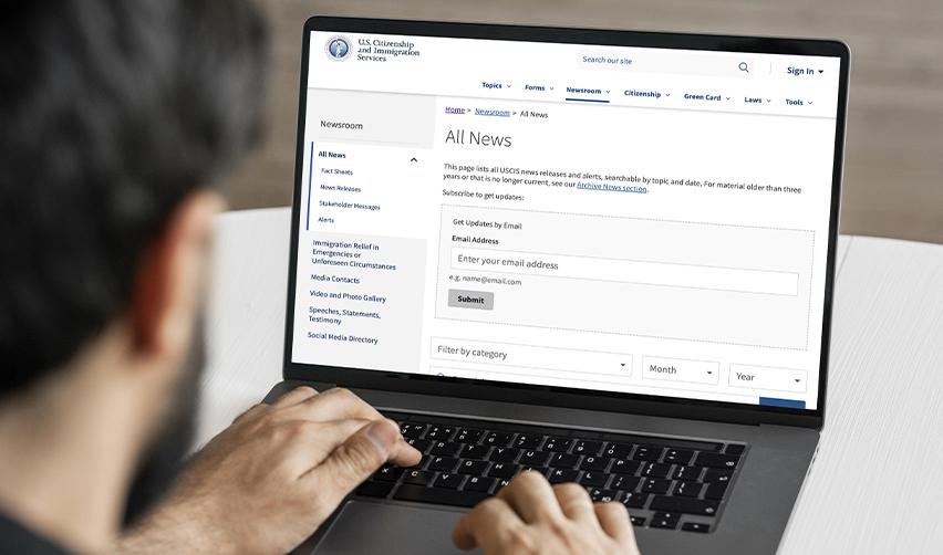 Investor reviewing the USCIS news page on a laptop, highlighting the importance of staying updated on EB5 policy changes and visa processing times.