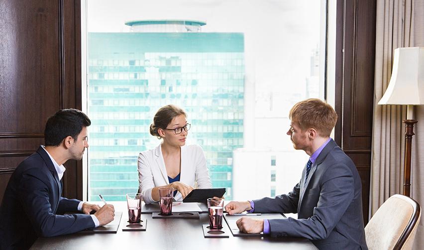 A business meeting in an office where an EB5 investor speaks with two regional center principals. Engaging with key decisionmakers helps investors assess experience and build trust before committing funds.