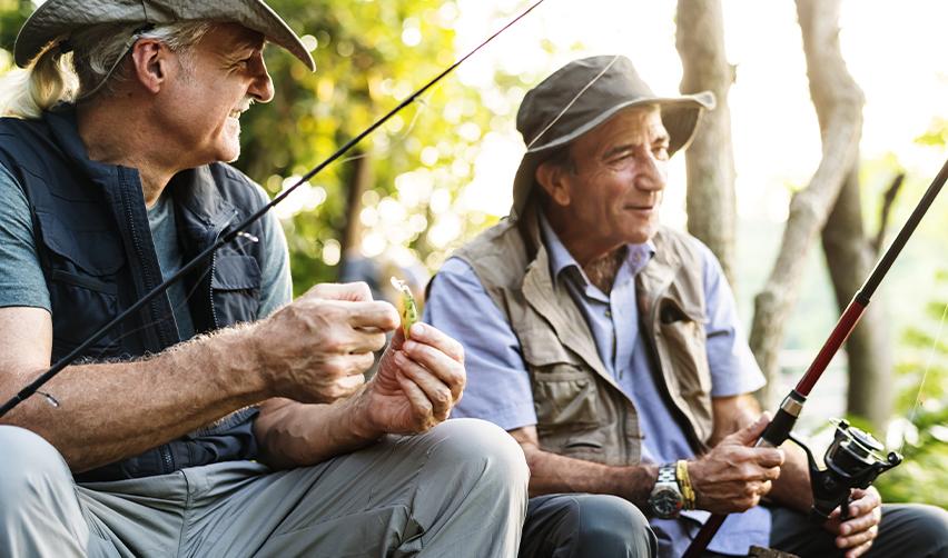 Two active adult residents of Twin Lakes, Georgia, enjoying a relaxing day of fishing, part of the community’s outdoor activities that promote wellness and social engagement.