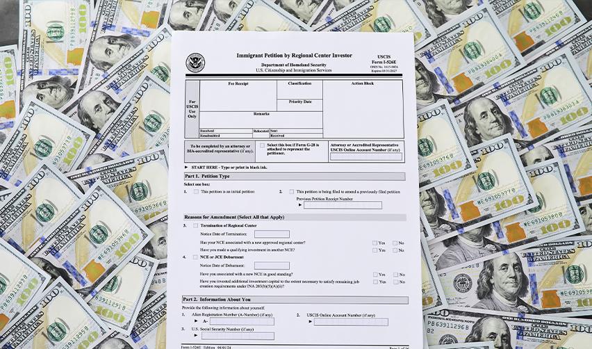 Form I-526E for EB5 immigrant investors placed on a background of U.S. dollar bills, representing investment requirements and funding for U.S. Green Card applications.