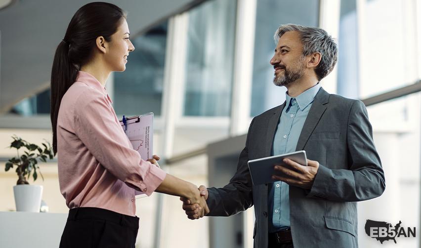 A professional handshake between an investor and an EB5 expert in a modern office, illustrating personalized guidance and secure financing solutions with EB5AN.