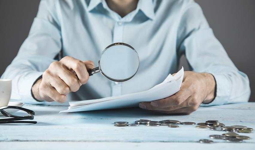 An EB5 investor or immigration attorney examining EB5 investment documents with a magnifying glass, symbolizing thorough due diligence. Reviewing regional center track records and project structures is crucial for financial and immigration success.