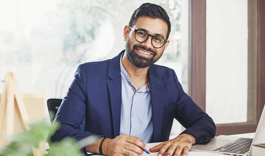 An Indian EB5 investor works at his desk, representing skilled immigrants navigating U.S. immigration policy changes that impact employment and residency options.