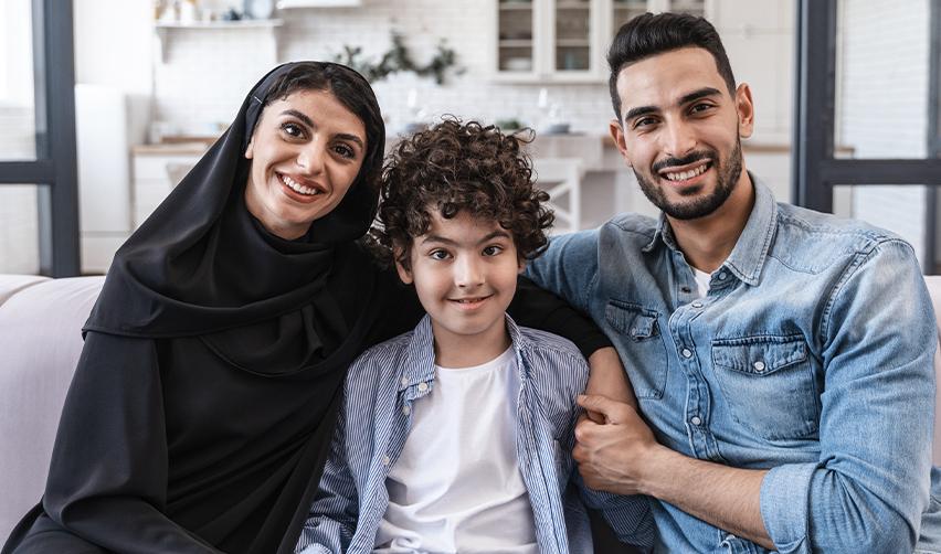 A family of green card holders who got their US green card through the EB5 visa smiling at the camera.