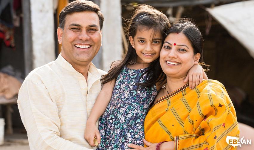 Indian parents with young daughter smiling outside with the EB5AN logo on the corner, highlighting family unity and the importance of timing in the EB5 immigration process.