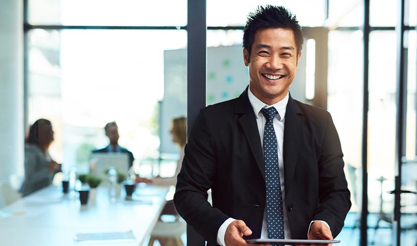 Confident professional in business attire standing in a modern office, representing successful EB5 investors on the path to U.S. citizenship.
