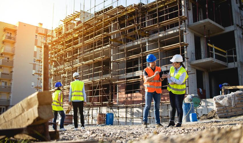 Construction workers in safety gear at an active building site, representing job creation and development tied to EB5 real estate projects.