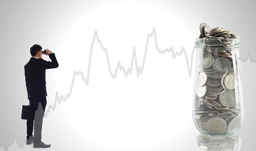 An EB5 green card applicant looking at a jar filled with coins against a fluctuating financial graph, representing the importance of evaluating EB5 investment risks.