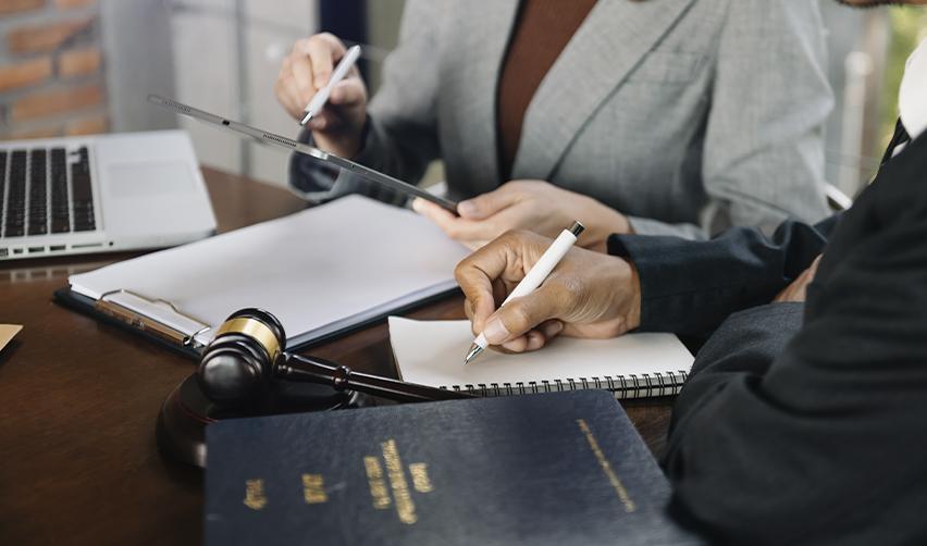 Immigration attorneys and EB5AN experts reviewing EB5 visa travel documents and adjustment of status forms at a law office.