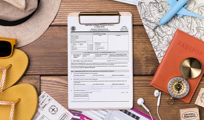USCIS Form I-485 for adjustment of status surrounded by passport, visa, boarding pass, and travel gear — symbolizing EB5 investors’ travel preparations.