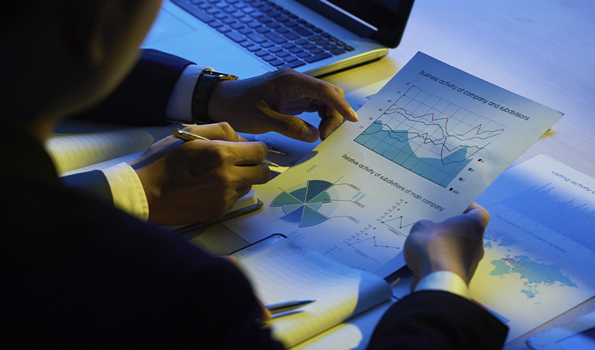 Investor analyzing financial data and business charts, evaluating the track record of regional center projects for successful EB5 investment.