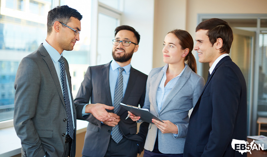 The EB5AN logo next to a business team discussing EB5 investment strategies, evaluating regional center projects, and collaborating with developers for real estate projects.