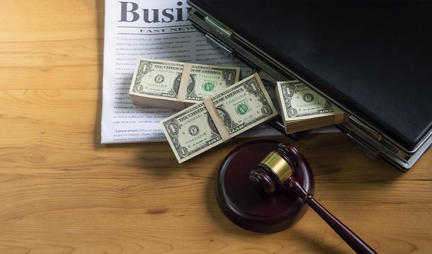 Gavel placed next to dollar bills and a briefcase on a desk, illustrating the documentation needed to prove the legal source of EB5 investment funds.