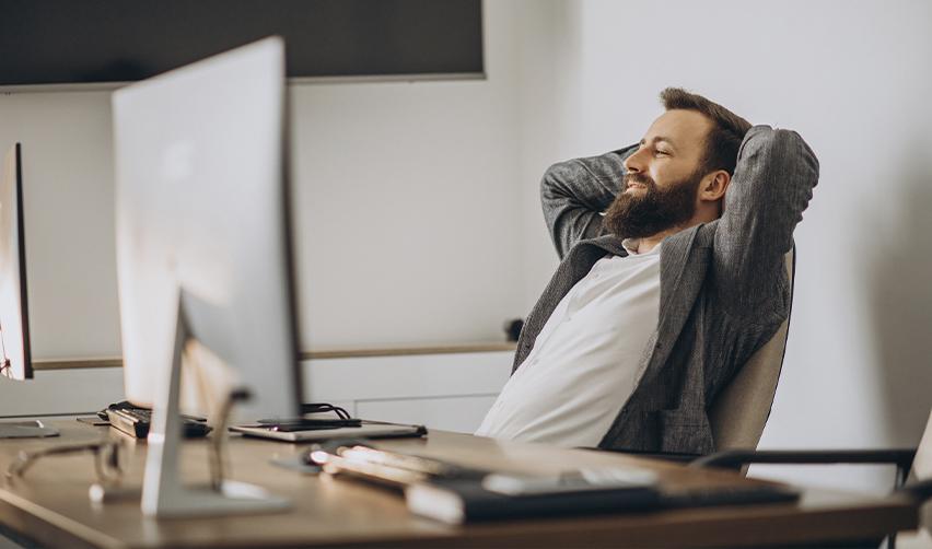 Confident EB5 investor relaxing in an office, representing the passive nature of regional center investments with no need for day-to-day management.