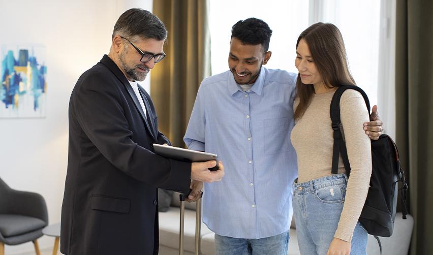 An EB5AN advisor showing information to an international couple, illustrating professional guidance for EB5 investors transferring funds from abroad.