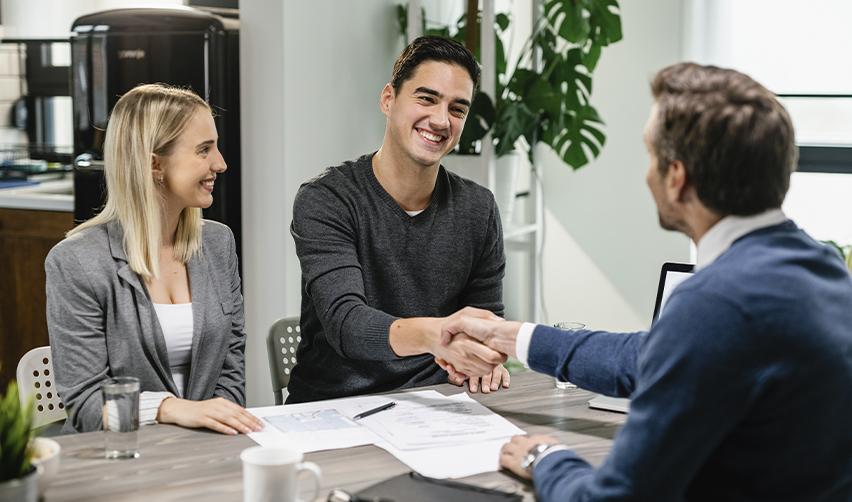 Happy investors shaking hands with a consultant after successful EB5 project selection, highlighting personalized support and fast-track processing.