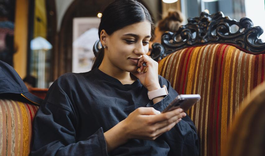 An EB5 investor on her phone, checking the state department's monthly visa bulletin for July 2025.