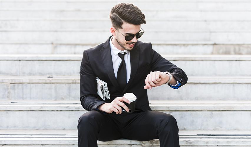 Young investor in formal attire checking the time, symbolizing the fast-tracked EB5 processing timelines for rural visa applicants.