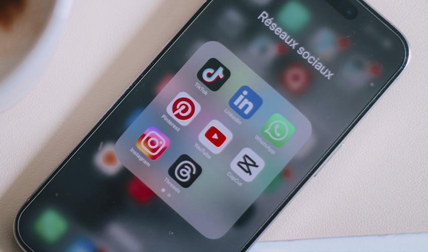 A smartphone screen displaying social media apps, highlighting how student visa holders and other immigrants may face scrutiny based on their online activity and lose their visa status.