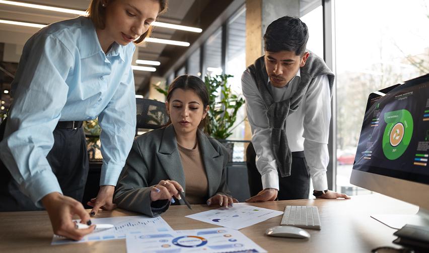 A focused group of professionals analyzing financial reports and EB5 investment data in an office, illustrating due diligence before selecting a regional center.