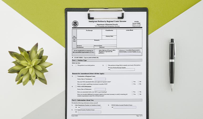 Form I-526E displayed on a clipboard, symbolizing the structured petition process available to india born investors seeking permanent residency.