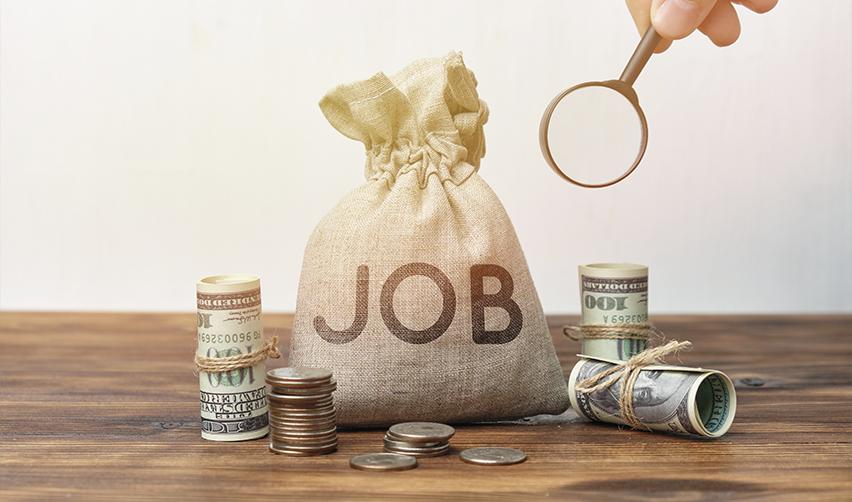 Money bag labeled “JOB” with U.S. currency and magnifying glass, representing EB5 investor capital funding job creation through job-creating entities.