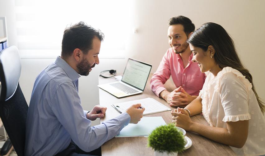 A young couple meeting with a financial advisor, representing the planning process for EB5 investment and securing U.S. residency for the family.