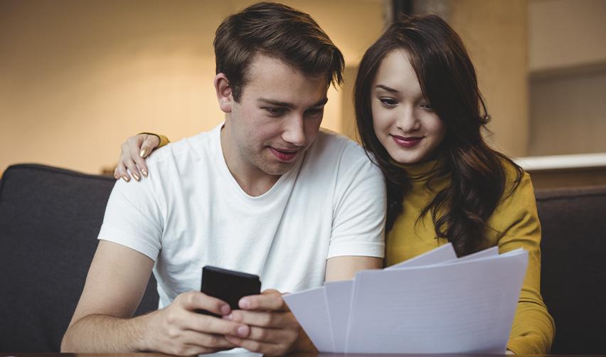 A young couple reviewing EB5 investment documents at home, symbolizing global investors considering the Bay Creek senior loan opportunity.