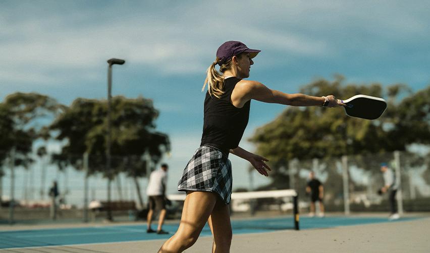 Female athlete playing pickleball at a coastal community facility, reflecting Bay Creek’s active lifestyle appeal.