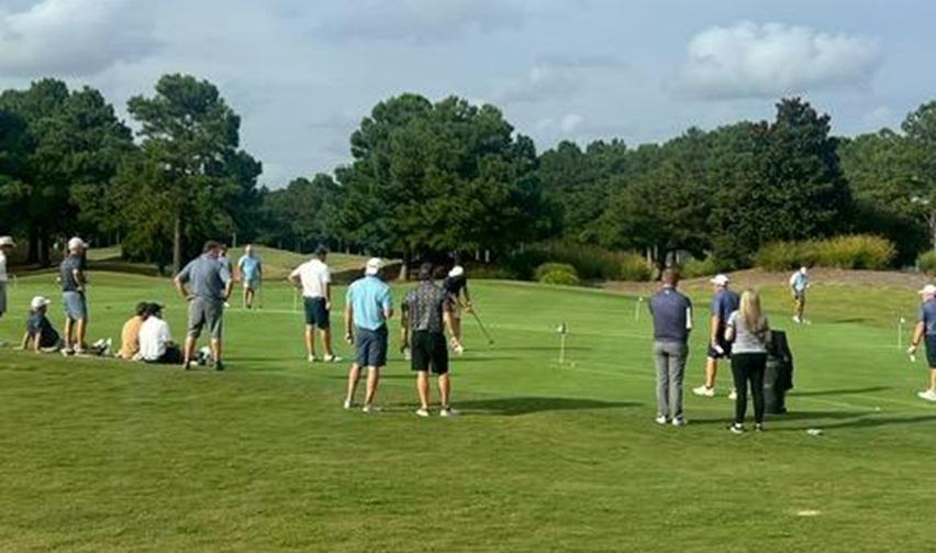 Golfers competing in a Bay Creek tournament on manicured greens, showcasing the championship courses that attract members.