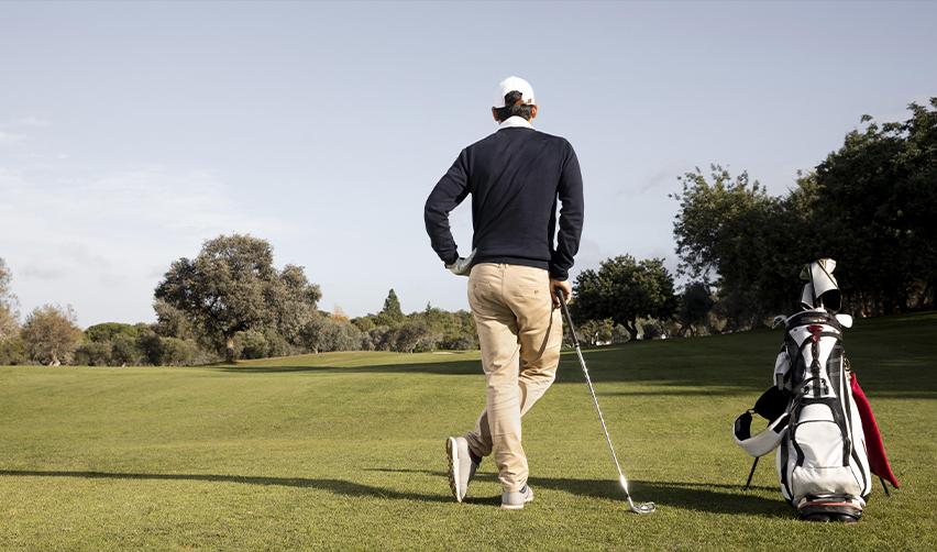 A golfer walking across the green at a championship course, showcasing the lifestyle and amenities at Bay Creek that support strong EB5 market demand.