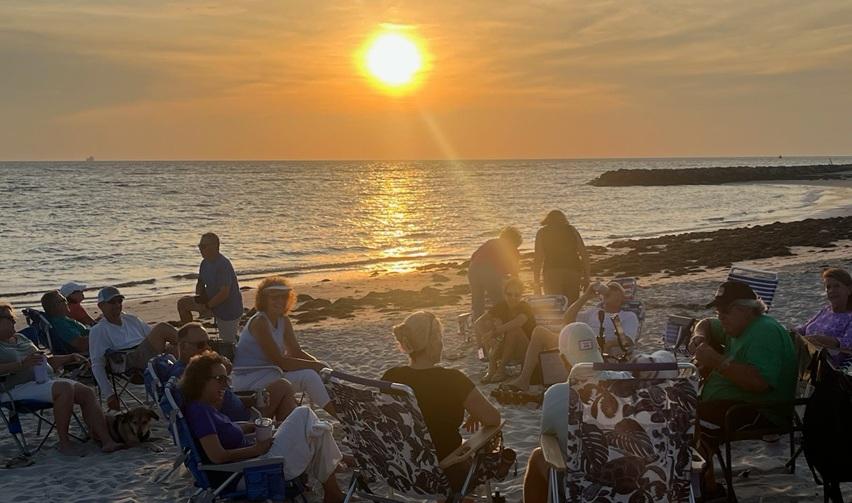 Residents gathered on Bay Creek’s private beach at sunset during a community music event, reflecting the vibrant lifestyle.