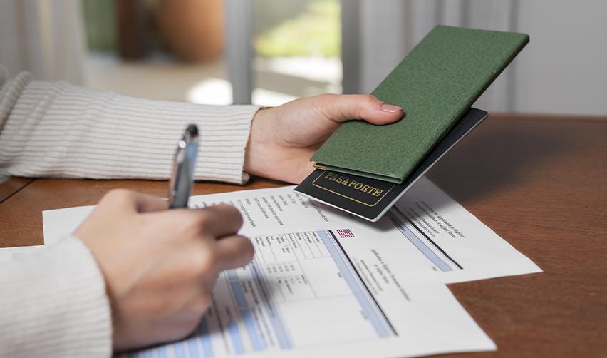 Investor preparing U.S. immigration paperwork with passport and forms, representing the EB5 path to a Green Card.