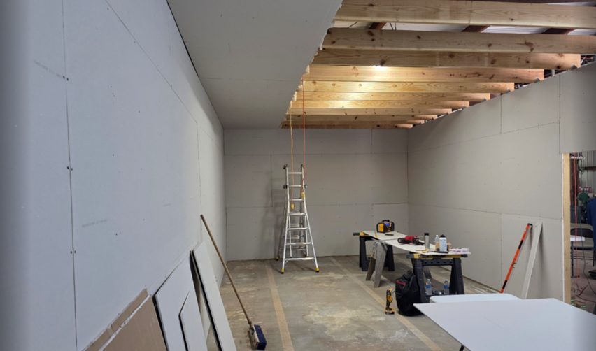 Interior construction progress at Bay Creek with drywall installation and tools in place.