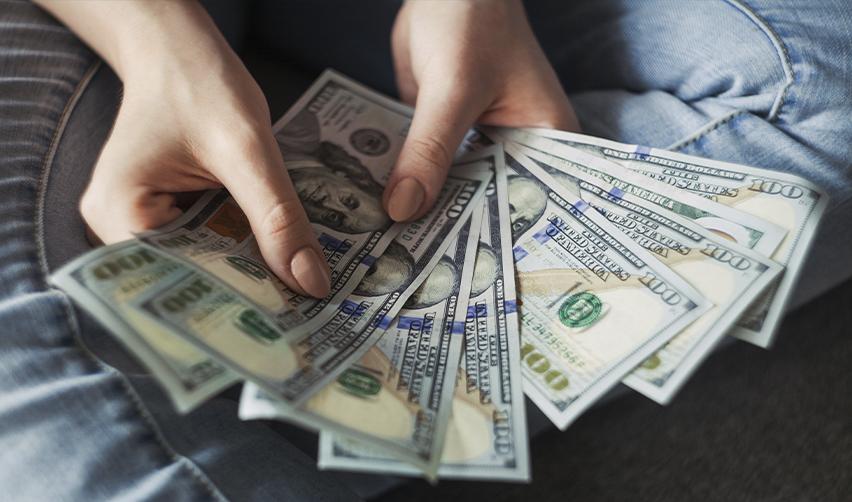 Investor holding U.S. dollars, reflecting reduced capital investment requirements for EB5 rural projects.