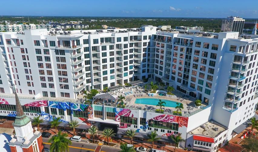 Aerial view of The Mark Sarasota downtown condo complex with rooftop pool deck and white façades, illustrating the completed Kolter project tied to EB5 investor repayment.
