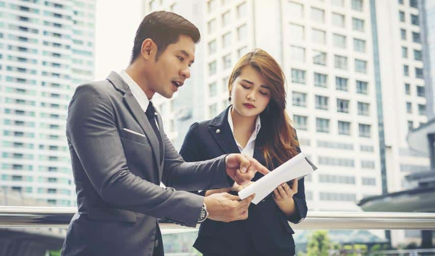 Two business professionals reviewing EB5 project documents together, representing investor consultation and decision-making.