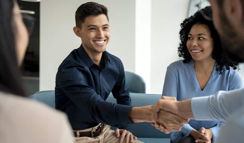Smiling professionals shaking hands during an EB5 consultation meeting, representing trust and partnership in U.S. immigration investment planning.