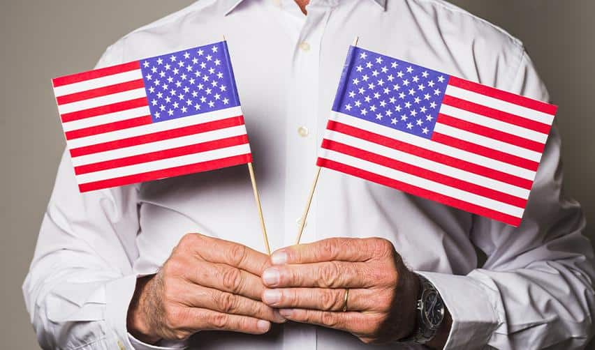 A new U.S. resident holding American flags, symbolizing permanent residency achieved through the EB5 program.