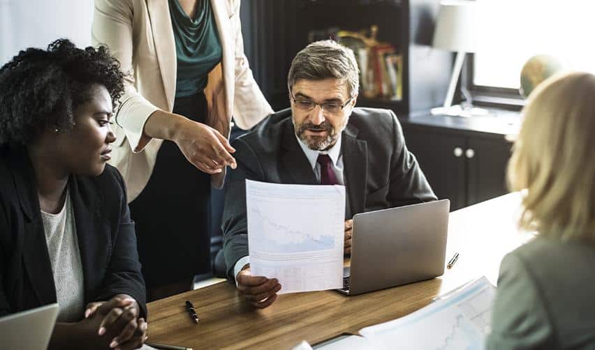 A group of professionals discussing financial and immigration strategies, reflecting collaboration and careful planning in EB5 investment decisions.
