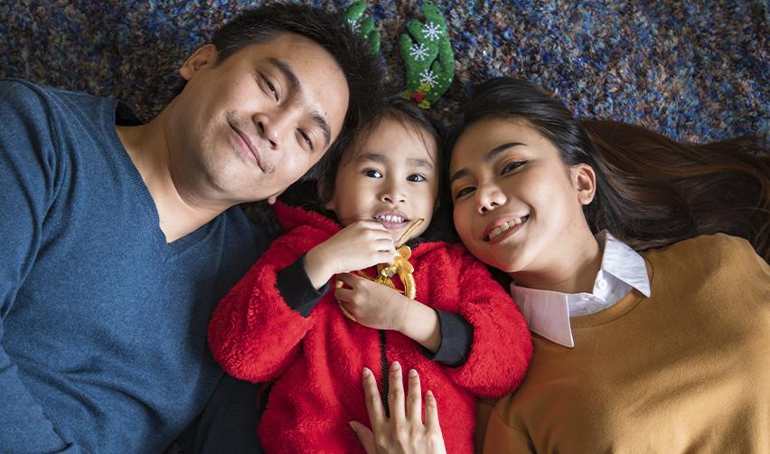 Happy family relaxing together at home, reflecting the unity and long-term stability EB5 investors gain when their spouse and children receive permanent residency.