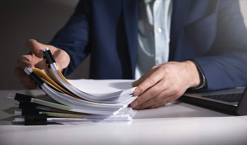 Stack of immigration paperwork and forms on a desk, symbolizing the documentation involved in EB5 concurrent filing and Adjustment of Status applications.