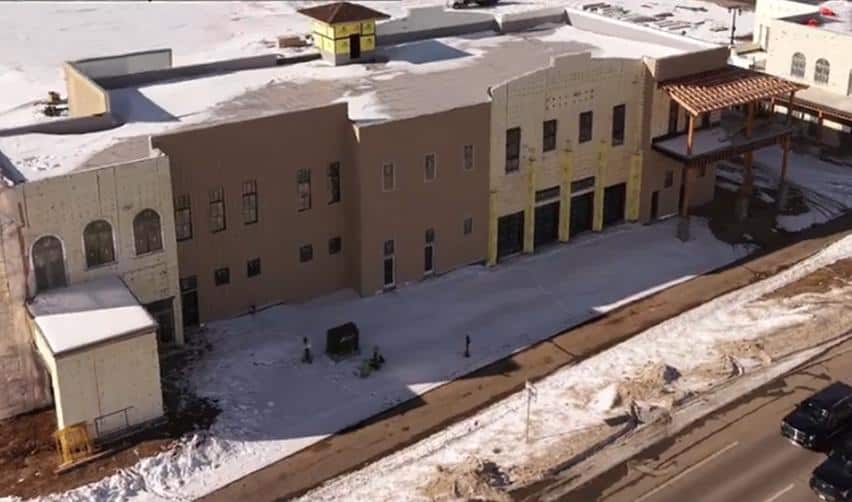 Street-level aerial view of Grand Park commercial buildings under construction, showing exterior façades, covered walkways, and winter site conditions supporting EB5 job creation.