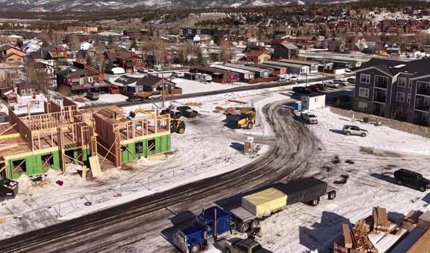 Close aerial view of Grand Park December construction progress with framed townhome structures, construction equipment, and ongoing EB5 development activity during winter conditions.