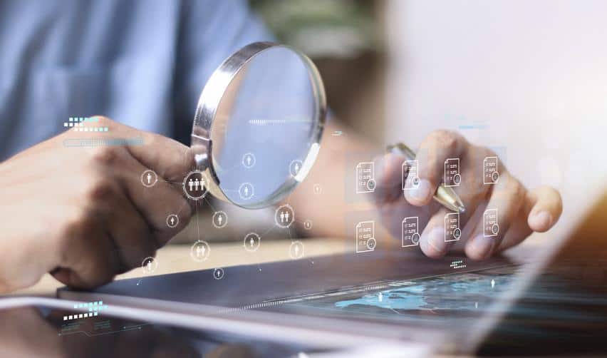A close-up of a magnifying glass hovering over digital files and data points, capturing the role of AI in helping EB5 investors cross-check information and review project documentation.
