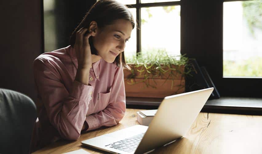 EB5 investor reviewing immigration information on a laptop in a home office setting, reflecting EB5 investors learning about Adjustment of Status and concurrent filing with digital tools.