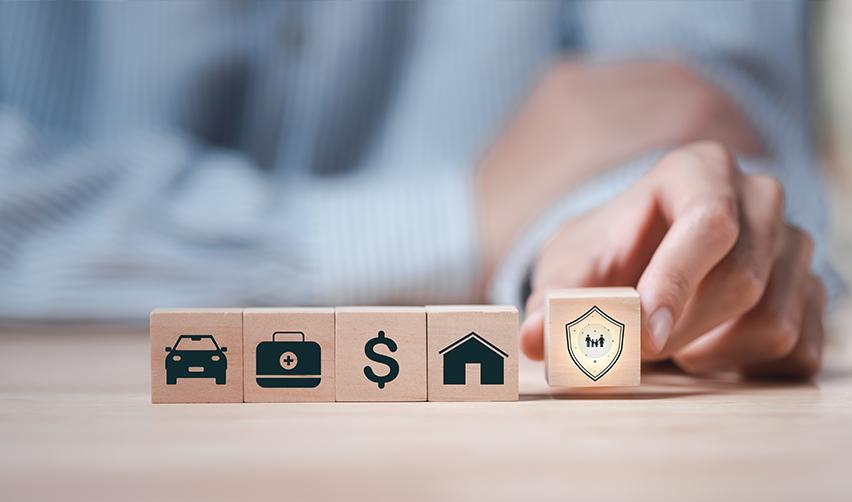 Wooden blocks displaying icons for assets and financial security, with a shield symbol highlighted, illustrating EB5 investors prioritizing capital protection through senior secured EB5 loan structures.