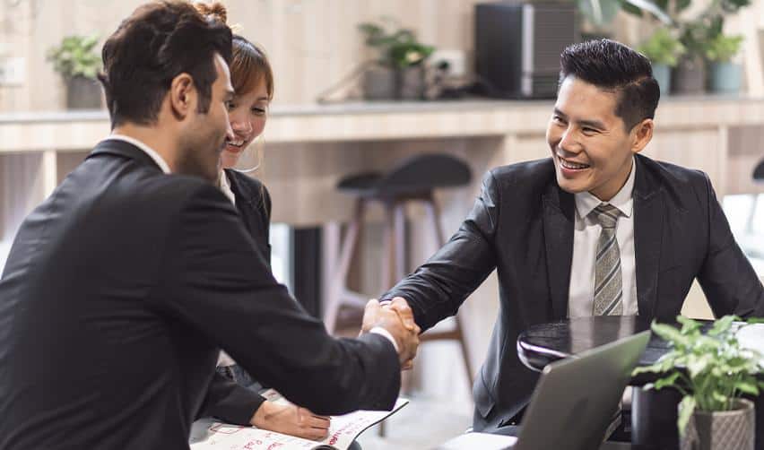 An EB5 investor shaking hands with an advisor across a desk, reflecting professional guidance and decision-making in the EB5 immigration process.